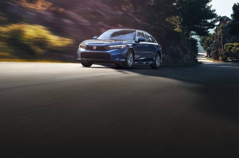 2027 Honda Civic LX in Blue Lagoon Pearl driving on a winding road (Compact Sedan)